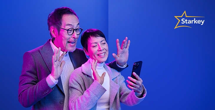 Image of senior couple waving at their mobile phone screen